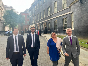Sam and friends walking down Downing Street